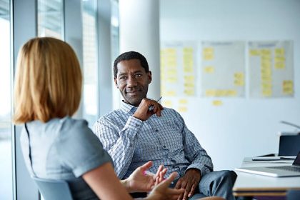 Shot of two colleagues talking together in a modern office